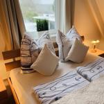 Schlafzimmer mit Bett, Kissen und Fenster. Möbel sind hölzern.