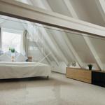 Schlafzimmer mit Dachschrägen, Bett und Schrank