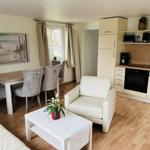 Wohnküche mit Esstisch, Sessel und Kücheneinrichtung