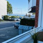 Blick vom Balkon auf Straße, Parkplatz und Hafen mit Booten.