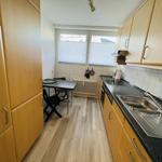 Küche mit Arbeitsfläche, Spüle und Essplatz.