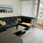 Wohnzimmer mit Sofa, Couchtisch und Balkonansicht.