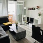 Wohn- und Essbereich mit Sofa, TV und Terrasse.