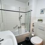 Badezimmer mit Badewanne, Dusche, Waschbecken und WC.