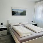 Schlafzimmer mit Doppelbett, zwei Nachttischen und Wandbild an der Wand.