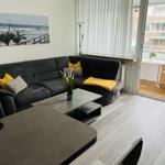 Wohnzimmer mit Sofa, Couchtisch und Balkonzugang.