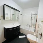 Badezimmer mit Badewanne, Dusche, Waschbecken und Toilette.