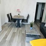 Wohn- und Essbereich mit Tisch, Stühlen, Sofa und Pflanzen.