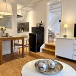 Wohnung mit Essbereich, Küche und TV. Treppen zur Schlafzimmer.