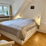 Schlafzimmer mit Dachfenster, Bett und Kleiderschrank.