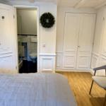 Schlafzimmer mit Bett, Stuhl und Blick in Bad