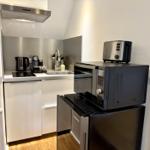 Küche mit Spüle, Kühlschrank, Mikrowelle und Toaster.