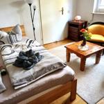 Ein Schlafzimmer mit Bett, Stuhl, Tisch und Fenster.