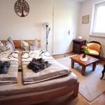 Zimmer mit Doppelbett, zwei Stühlen und Fenster