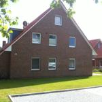 Rotes Ziegelhaus mit Gartenterrasse und grünem Rasen