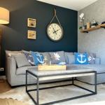 Wohnzimmer mit Sofa, Tisch und Wanduhr.