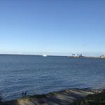 Meeresblick mit Schiff und Hafen im Hintergrund