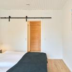 Schlafzimmer mit Bett, Schiebetür und Wandbild