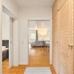 Flur mit Holzwand und Blick in Wohn- und Schlafzimmer