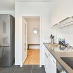 Küche mit Spüle, Kühlschrank und Durchgang zur nächsten Raum.