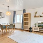 Wohn- und Essbereich mit Holzmöbeln, Fernseher und Wanddekoration.