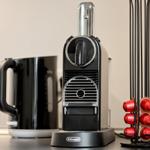 Kaffeevollautomat mit Kapseln und Wasserkocher auf Arbeitsfläche