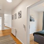 Flur mit Schlafzimmer, Holzboden und Wandbildern