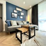Wohnzimmer mit Sofa, Tisch und blauer Wand mit Bildern.