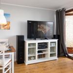 Living and dining area with TV, table, chairs, and window.