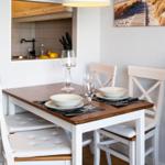 Dining area with table and chairs, kitchen area in background