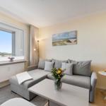 Wohnzimmer mit Sofa, Tisch und Fensterblick