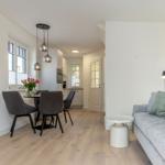 Wohn- und Essbereich mit Sofa, Esstisch und Küche.