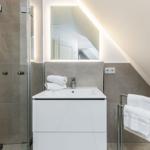 Badezimmer mit Dusche, Waschbecken und Handtüchern