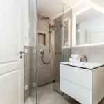 Moderne Badewanne mit Dusche, Waschbecken und Spiegel.