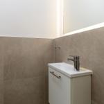 Bad mit Waschbecken, Spiegel und Fliesenwand