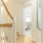 Hausflur mit Treppe und Blick in die Toilette.