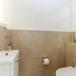 Badezimmer mit Waschbecken, Toilette und Spiegelschrank