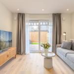 Wohnzimmer mit Sofa, Fernseher und Terrassentür.