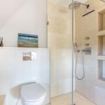 Dusche mit Glaswand, Toilette und Wandbild