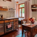 Küche mit Essbereich, Holztisch, Fenster und Küchengeräten.