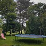 Spielplatz im Gartenbereich mit Wippe, Schaukel und Trampolin