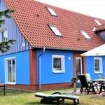 Blau gestrichenes Haus mit rotem Dach und Gartenmöbeln.