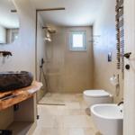 Bathroom with stone sink, shower, and toilet
