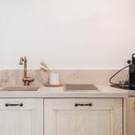 Kitchenette with sink, induction cooktop, and coffee machine.