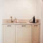 Kitchenette with sink, faucet, and coffee machine.