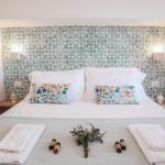 Double bed with mosaic tile headboard and two wooden shelves.