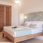 Bedroom with wooden bed, wooden closet, and patterned headboard.