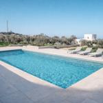 Pool mit Liegen und Blick auf Olivenhaine und das Meer.