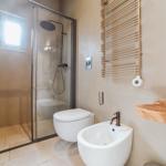 Badezimmer mit Dusche, Toilette und Waschbecken.