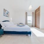 Schlafzimmer mit Bett, Nachttisch und Kleiderschrank. Blick in das Badezimmer.